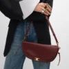 Bolso Little Halfmoon Soft Triomphe en piel de cordero flexible y brillante Bolso Little Halfmoon Soft Triomphe en piel de cordero flexible y brillante