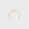 Brazalete asimétrico Triomphe en latón con acabado dorado
