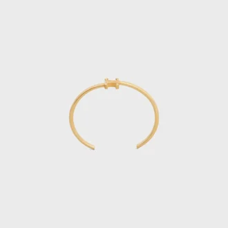 Brazalete asimétrico Triomphe en latón con acabado dorado