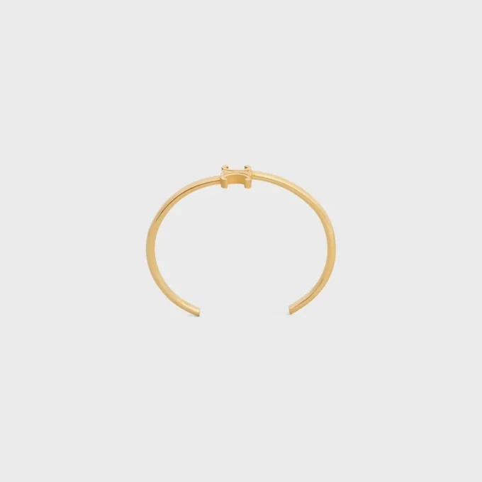 Brazalete asimétrico Triomphe en latón con acabado dorado