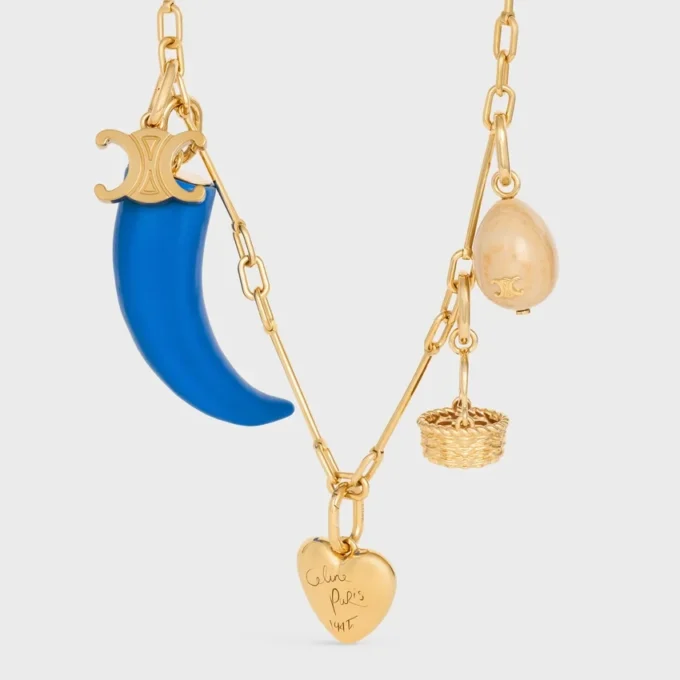 Dije pequeño en forma de cuerno de resina, cuero y latón con acabado dorado Dije pequeño en forma de cuerno de resina, cuero y latón con acabado dorado