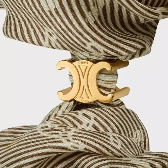Goma para el pelo CELINE Triomphe Diagonale en seda y latón con acabado dorado Goma para el pelo CELINE Triomphe Diagonale en seda y latón con acabado dorado